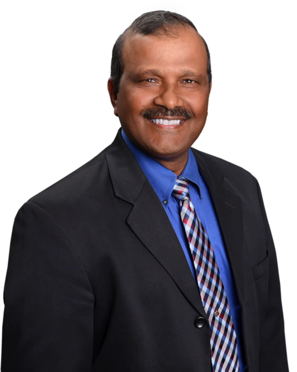 Kris Persaud, Realtor, in a black suit, blue shirt and checked tie