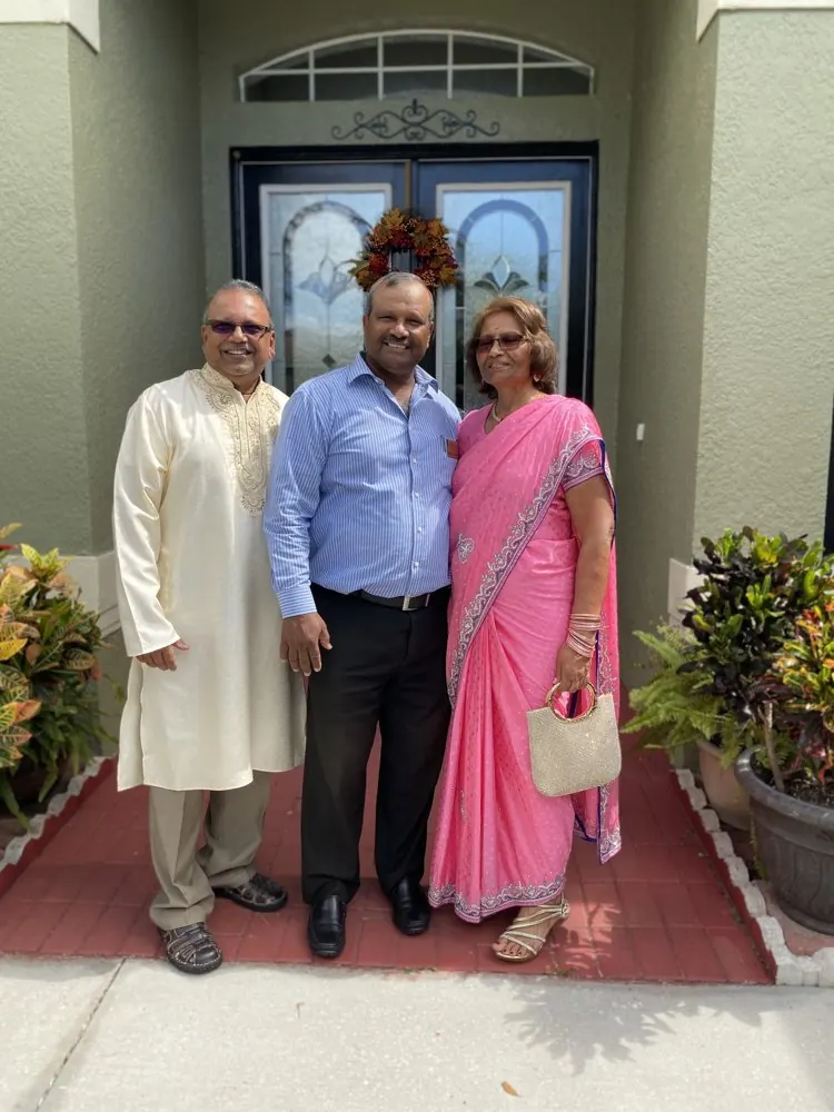 Kris Persaud with family at a front door
